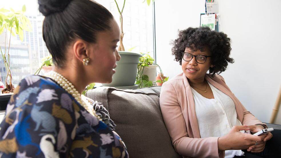 Two women talking on couch