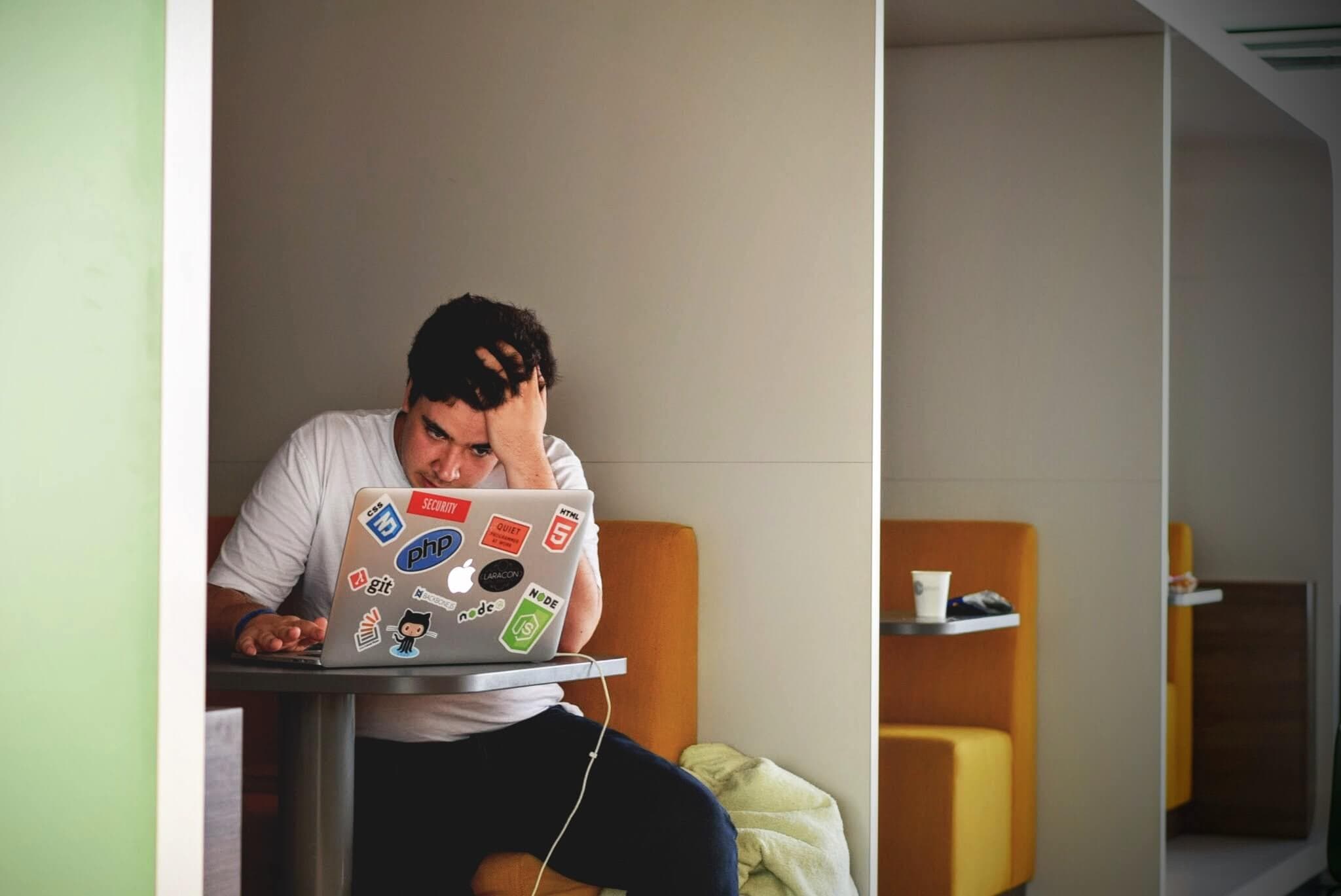 Stressed employee working alone on a laptop
