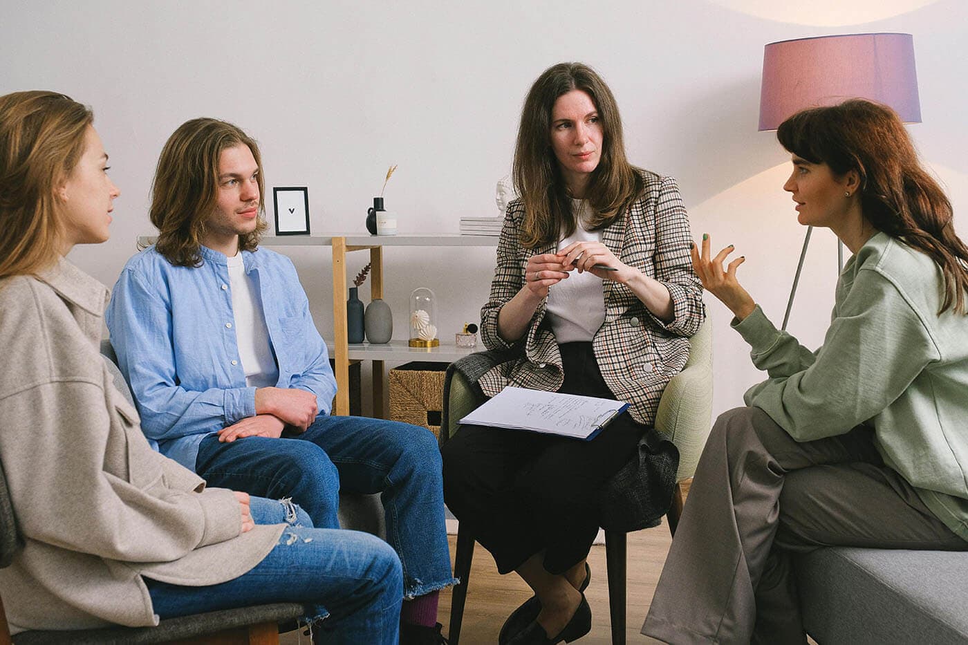 Four colleagues talk in a circle of chairs