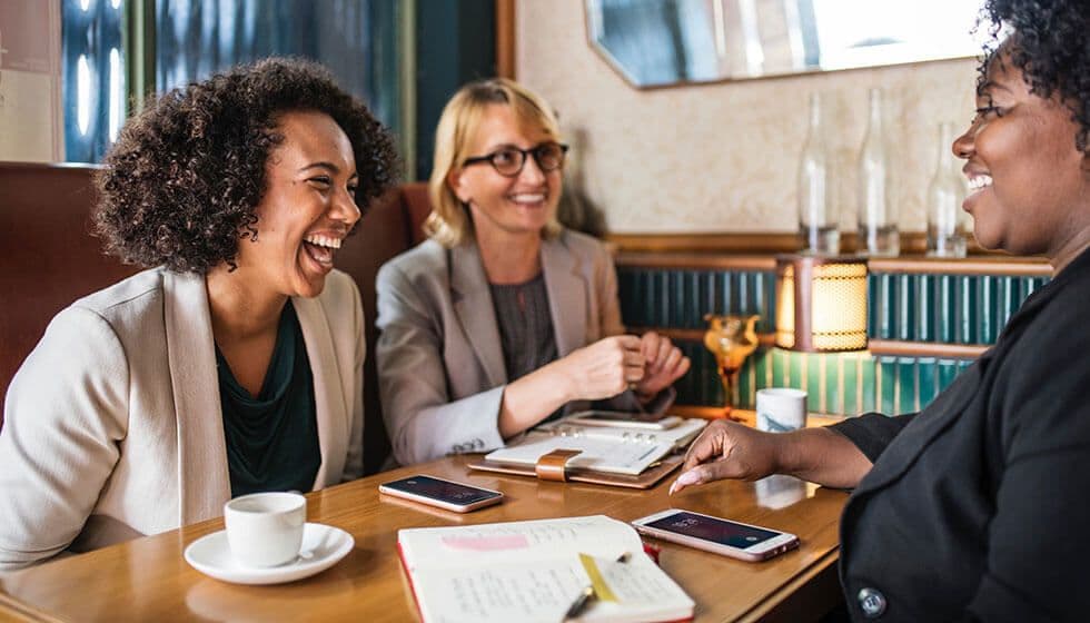 three-women-workplace-mentoring-session-about-employee-wellbeing